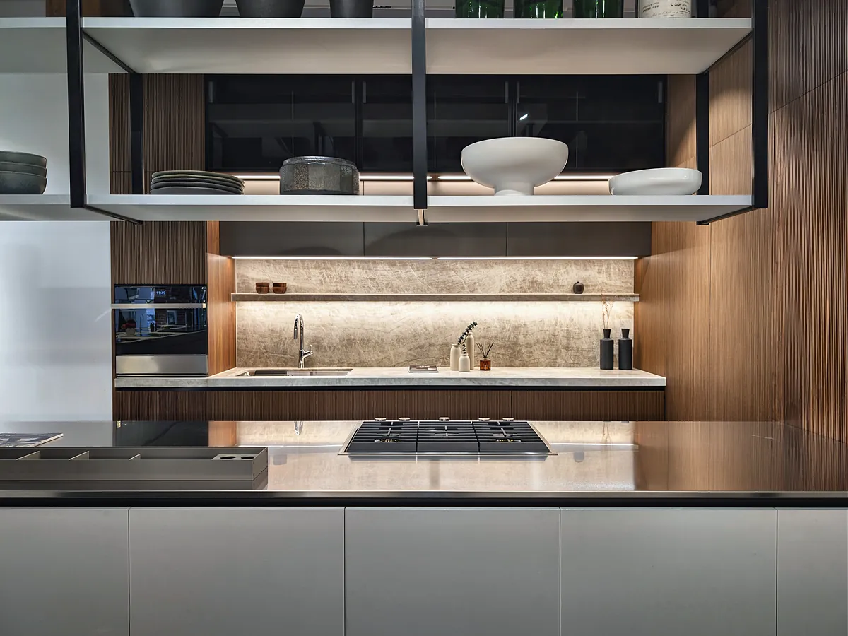 A walnut-panelled kitchen with a stone backsplash, a gas hob and black-framed open shelves.